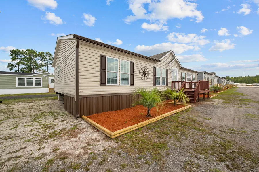 Double Pantry manufactured home with a wood deck and landscaped skirting