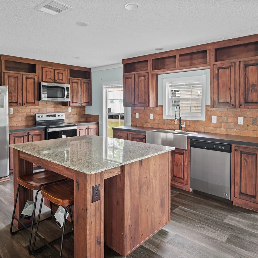 Kitchen with dark wood cabinets, a granite island and stainless appliances